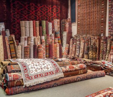 Variety of the gorgeous oriental carpets in traditional carpet store in Middle East. Pile of beautiful handmade carpets on the traditional Middle East market bazaar.